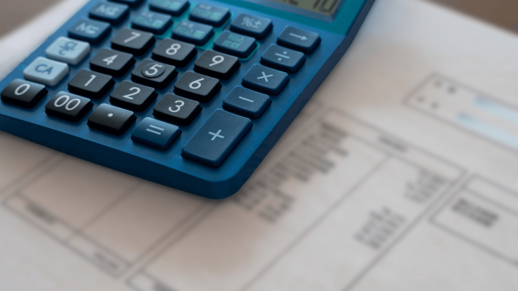 Un bureau RH avec un calculatrice et un bulletin de paie pour mettre en place la prime partage de la valeur.